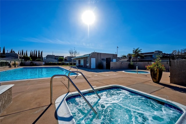 view of swimming pool with a community hot tub and a patio