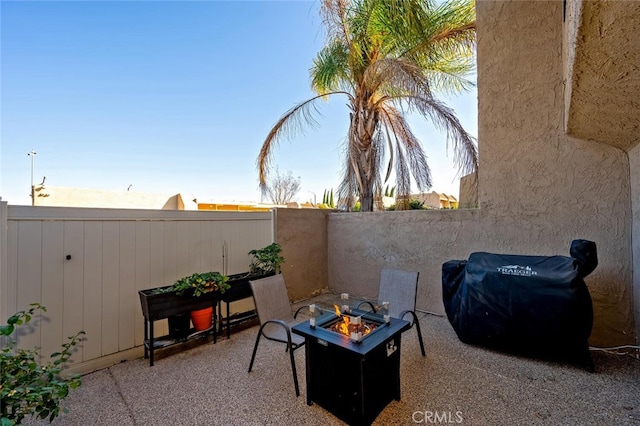 view of patio with area for grilling and a fire pit