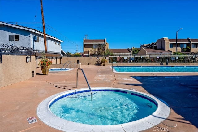 view of pool featuring a community hot tub and a patio