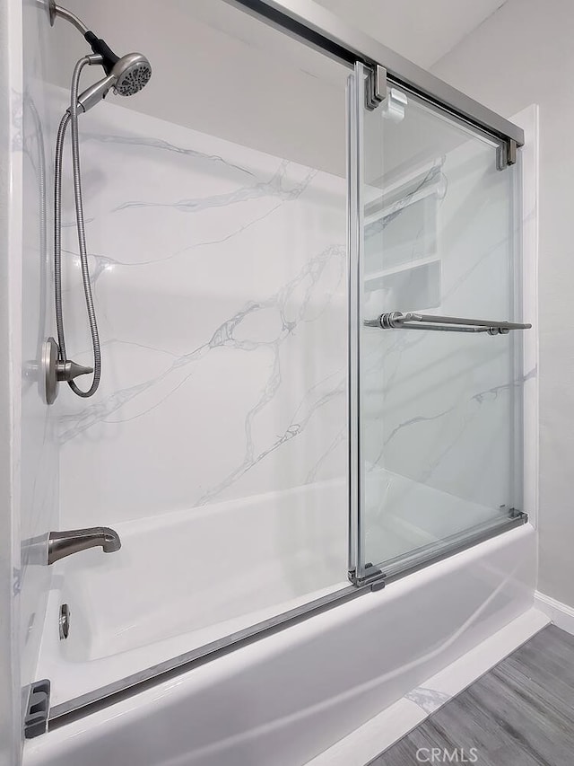 bathroom featuring bath / shower combo with glass door and hardwood / wood-style floors