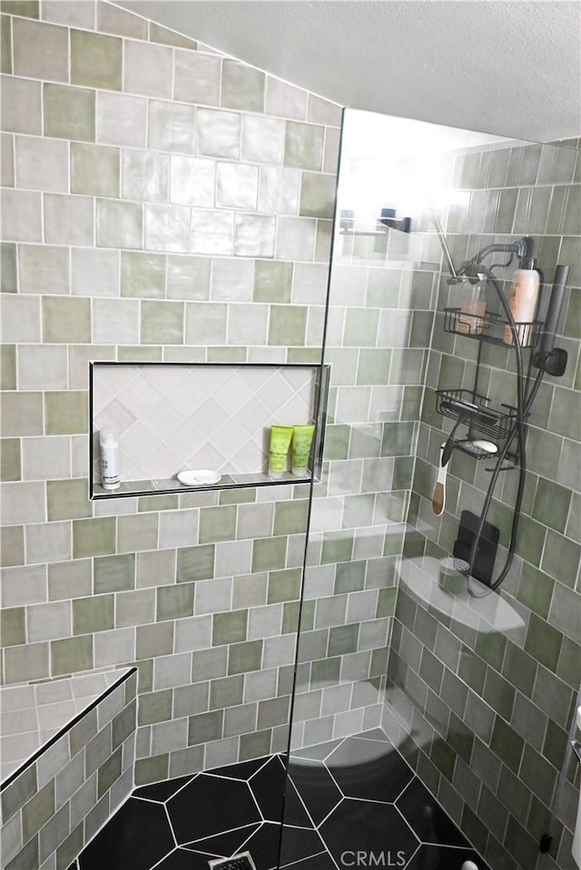 bathroom with a textured ceiling and a shower with shower door