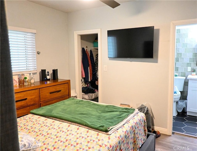 bedroom featuring hardwood / wood-style flooring, ensuite bathroom, and ceiling fan