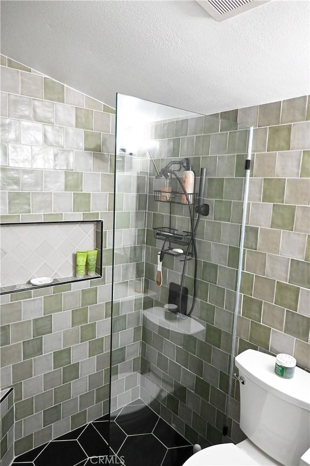 12530 Birch Ave, Hawthorne, CA 90250 - bathroom with walk in shower, a textured ceiling, and tile walls