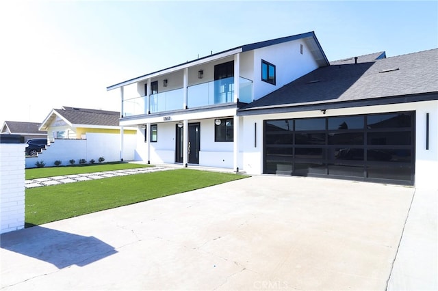 view of front of property with a balcony, a garage, and a front lawn