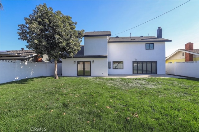 rear view of house with a patio area and a yard