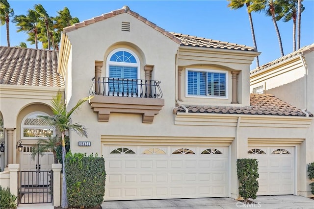 mediterranean / spanish-style home featuring a garage and a balcony