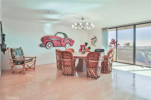 dining room with a chandelier, light hardwood / wood-style flooring, and floor to ceiling windows