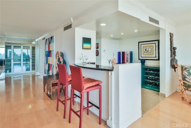 bar featuring light hardwood / wood-style flooring and ornamental molding