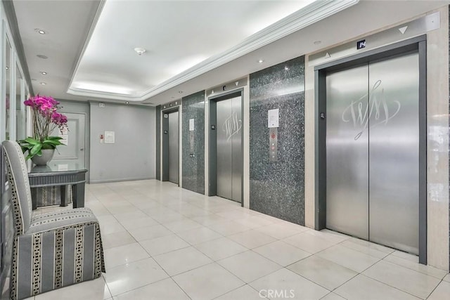 hall with elevator, a raised ceiling, and light tile patterned flooring