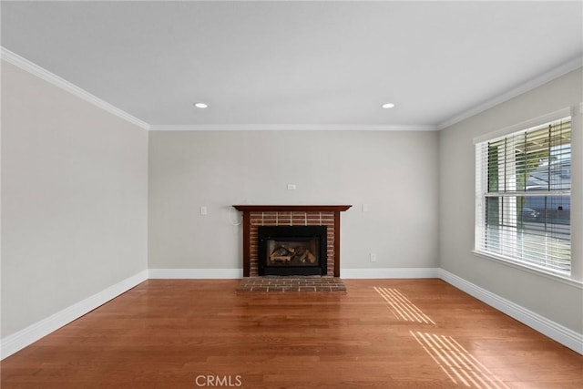 unfurnished living room with ornamental molding, a fireplace, and hardwood / wood-style floors