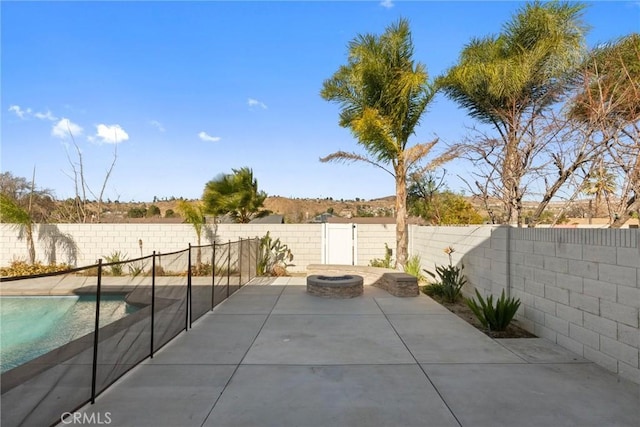 view of patio / terrace with a fenced in pool and an outdoor fire pit