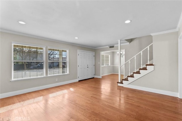 entryway with hardwood / wood-style flooring, crown molding, and a notable chandelier