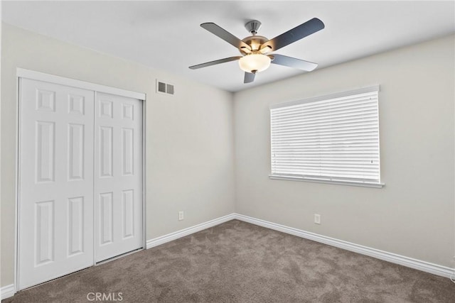 unfurnished bedroom featuring carpet flooring, ceiling fan, and a closet