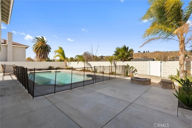 view of swimming pool with a patio and an outdoor fire pit