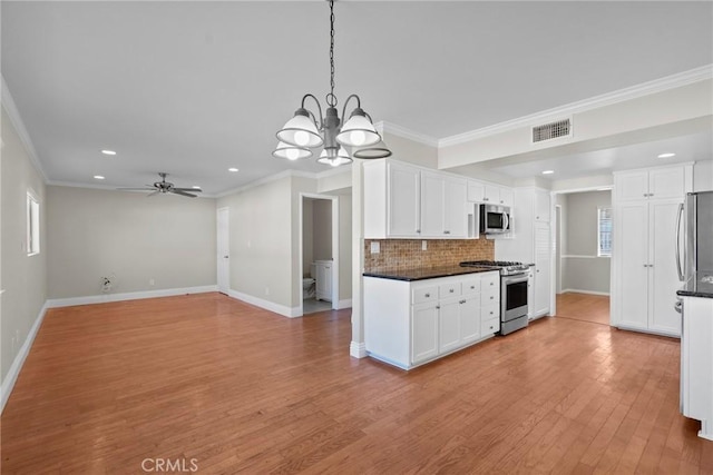 kitchen featuring backsplash, ornamental molding, stainless steel appliances, and white cabinets