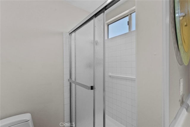 bathroom with an enclosed shower and toilet