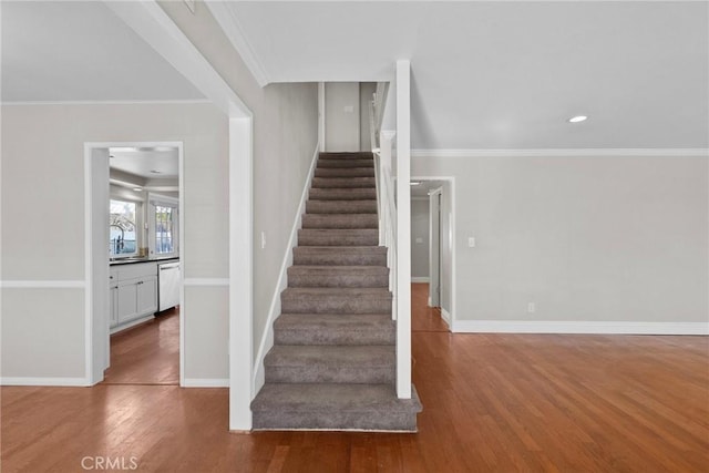 stairway featuring hardwood / wood-style floors and ornamental molding