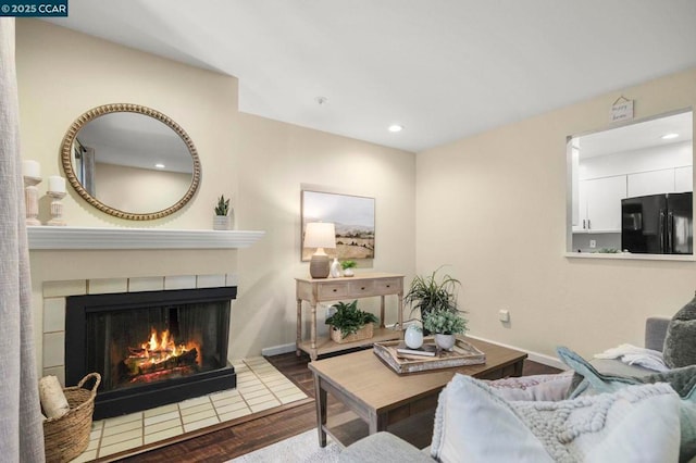 living room with hardwood / wood-style flooring and a tile fireplace