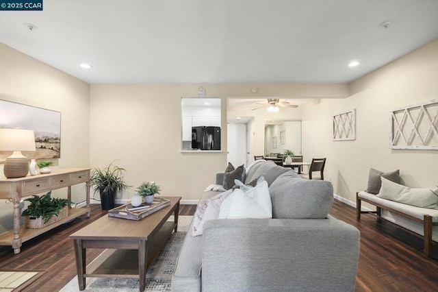 living room with ceiling fan and dark wood-type flooring