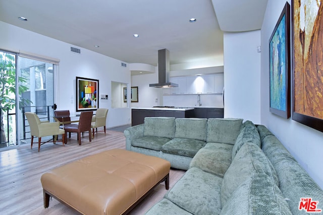 living room with sink and light wood-type flooring