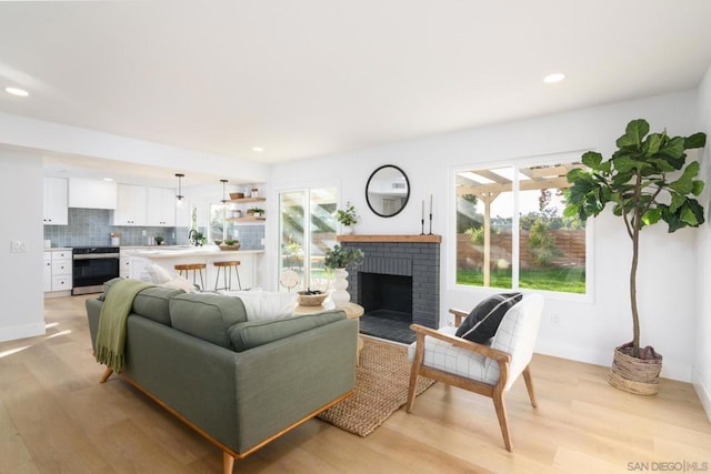 living room featuring light hardwood / wood-style floors and a brick fireplace