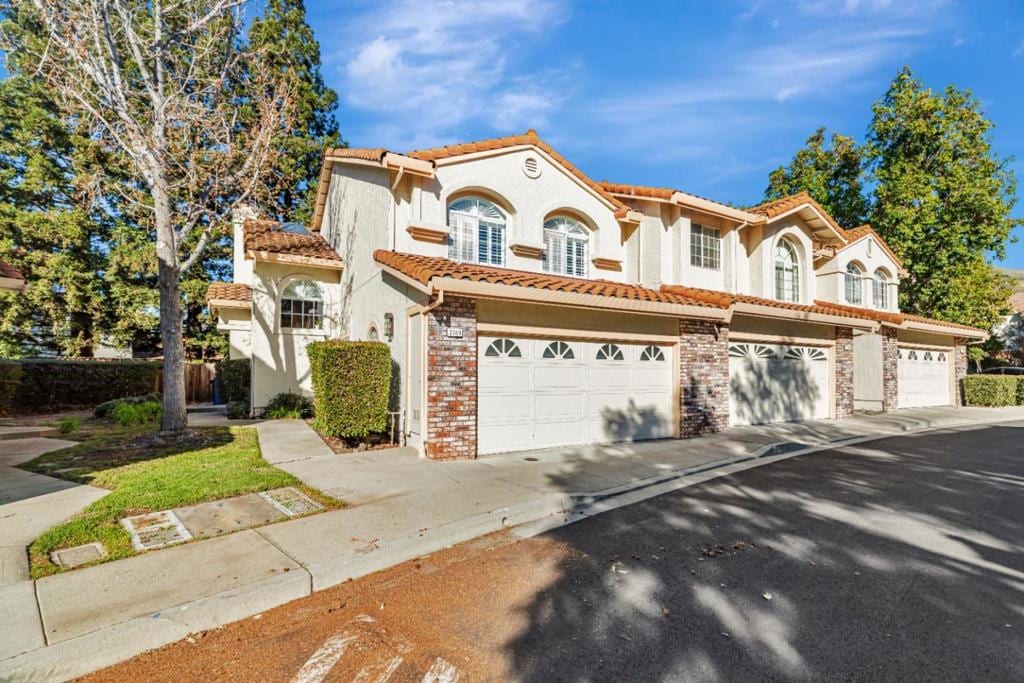 mediterranean / spanish-style house with a garage