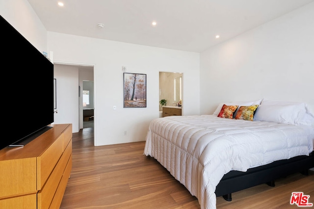 bedroom featuring light hardwood / wood-style flooring and connected bathroom