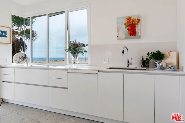 interior space featuring sink, white cabinets, and a water view