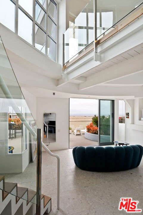 living room featuring a high ceiling and beam ceiling