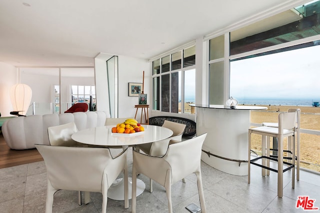 dining area with a water view and expansive windows