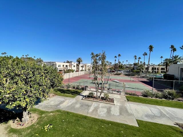 surrounding community featuring tennis court and a yard