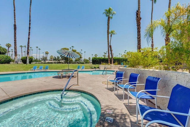 view of swimming pool featuring a yard and a hot tub