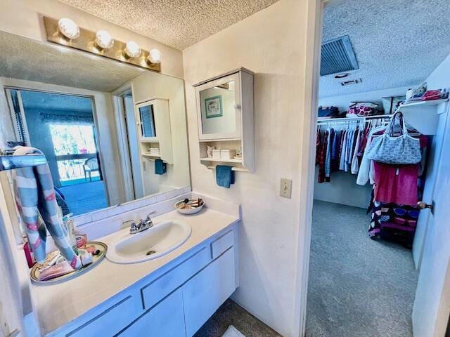 bathroom with a textured ceiling and vanity