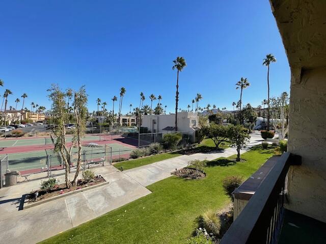 view of community with tennis court and a yard