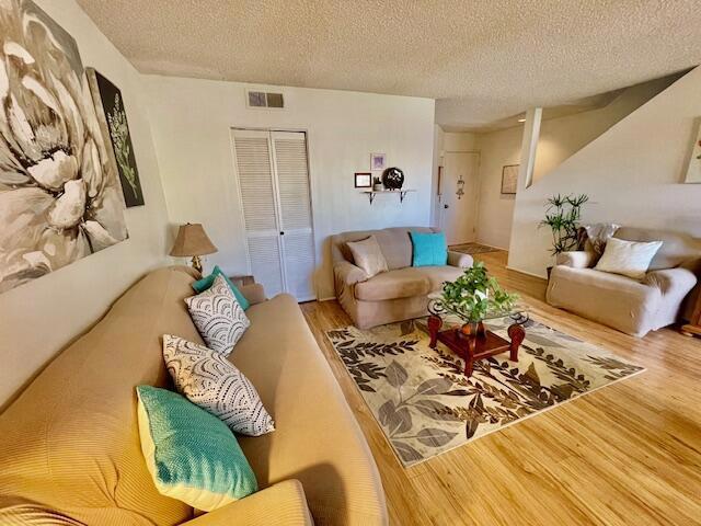 living room featuring a textured ceiling and hardwood / wood-style floors