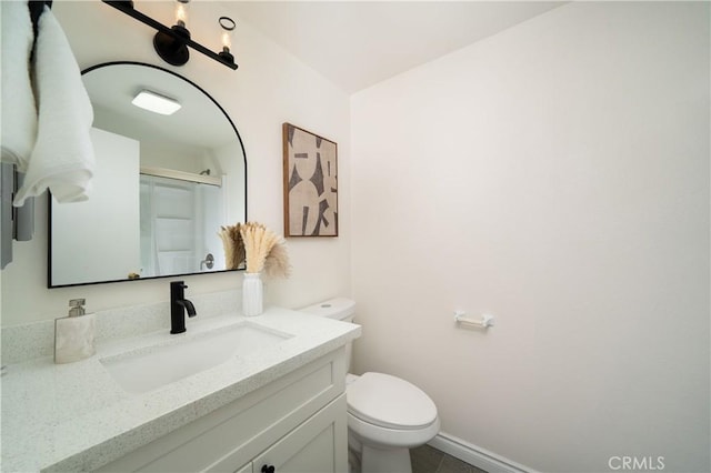 bathroom featuring vanity, toilet, and an enclosed shower