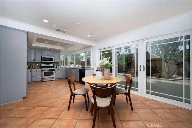 tiled dining room with crown molding, a raised ceiling, and french doors