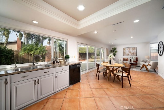 kitchen with sink, light tile patterned floors, dishwasher, ornamental molding, and a raised ceiling