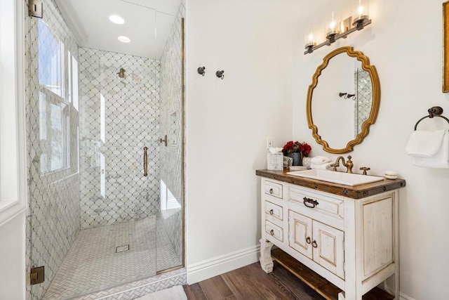 bathroom with wood-type flooring, walk in shower, and vanity