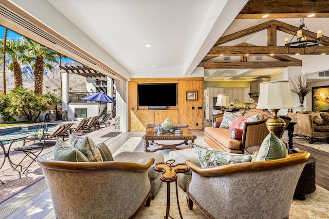 living room featuring light hardwood / wood-style flooring, lofted ceiling with beams, and an inviting chandelier