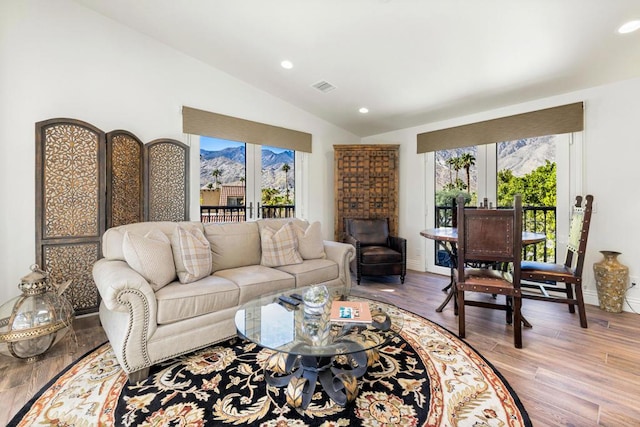 living room featuring hardwood / wood-style floors, vaulted ceiling, and french doors