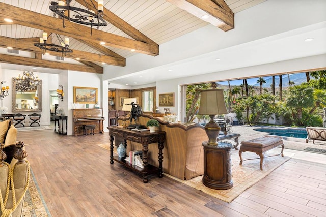 living room with hardwood / wood-style floors, plenty of natural light, beamed ceiling, and high vaulted ceiling