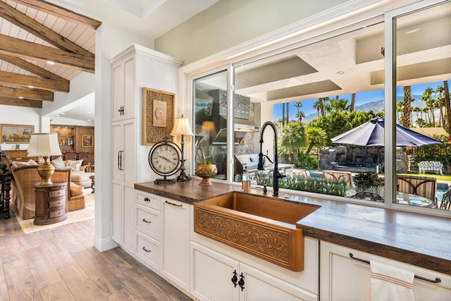 kitchen featuring white cabinets, light hardwood / wood-style flooring, and sink