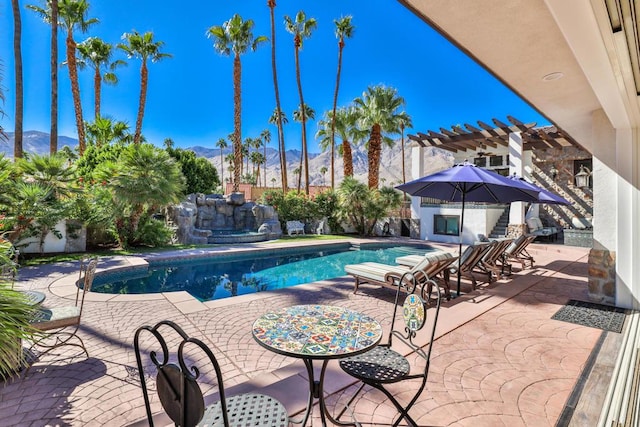 view of swimming pool featuring a mountain view, a pergola, and a patio area