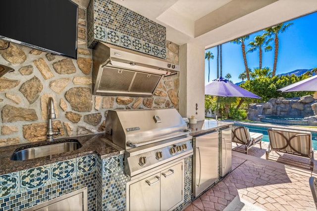 view of patio with sink, exterior kitchen, and a grill