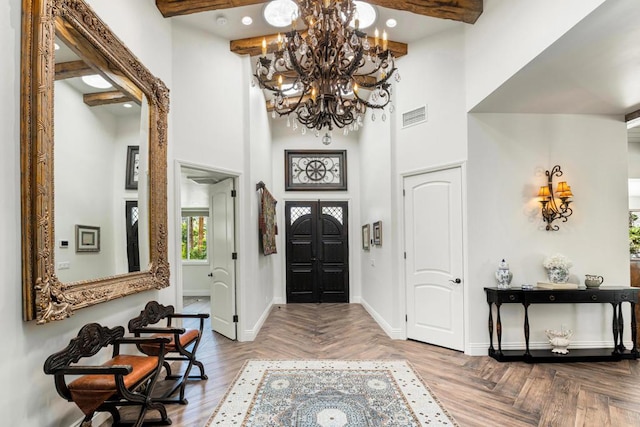 foyer featuring a high ceiling, a chandelier, beamed ceiling, and parquet floors