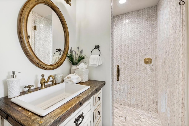 bathroom featuring tiled shower and vanity