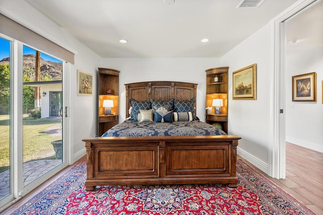 bedroom featuring access to exterior and light wood-type flooring