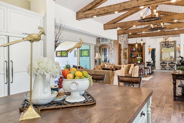 dining area featuring hardwood / wood-style flooring, a chandelier, wooden ceiling, and lofted ceiling with beams