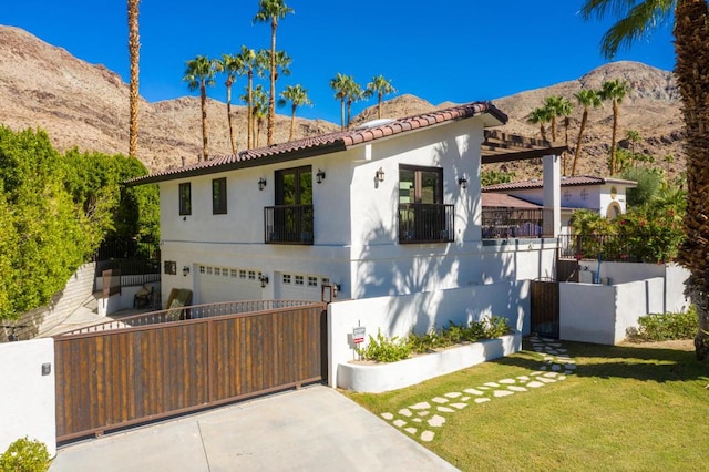 view of front of house featuring a mountain view, a garage, and a front lawn